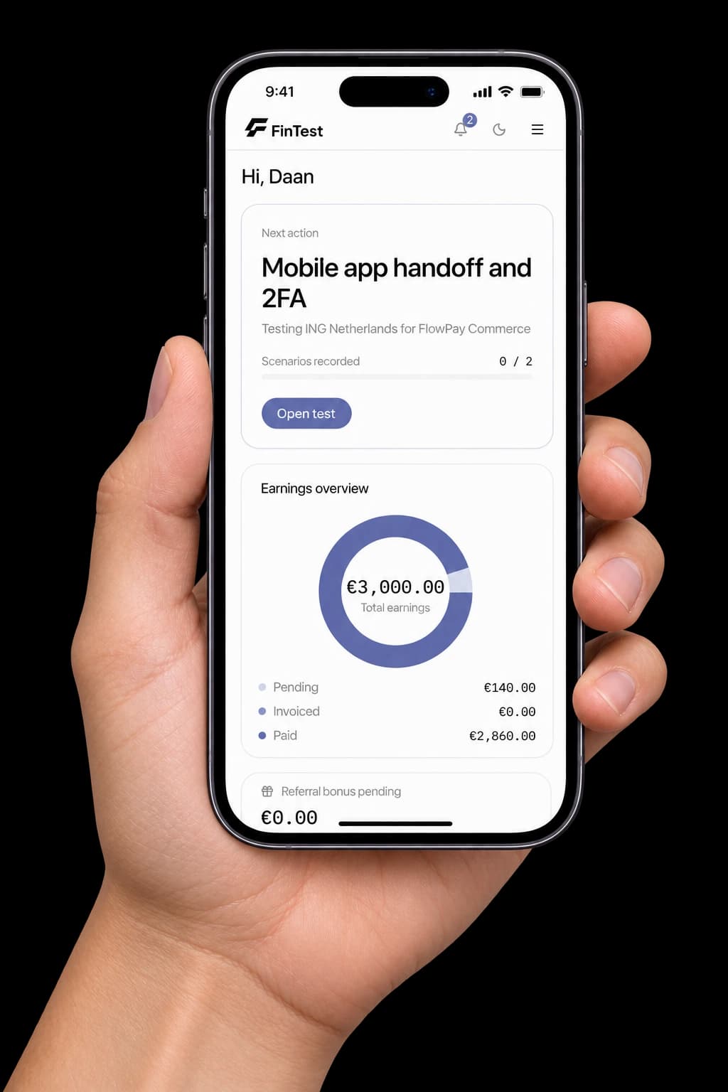 A hand holding a phone with the FinTest tester dashboard open, showing the next test to run and an earnings overview